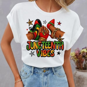 Może przedstawiać: Biała koszulka z kolorową grafiką. Projekt zawiera napis "JUNETEENTH VIBES", parę but&oacute;w, pięść i gwiazdy. Kolory to czerwony, zielony, ż&oacute;łty i czarny.