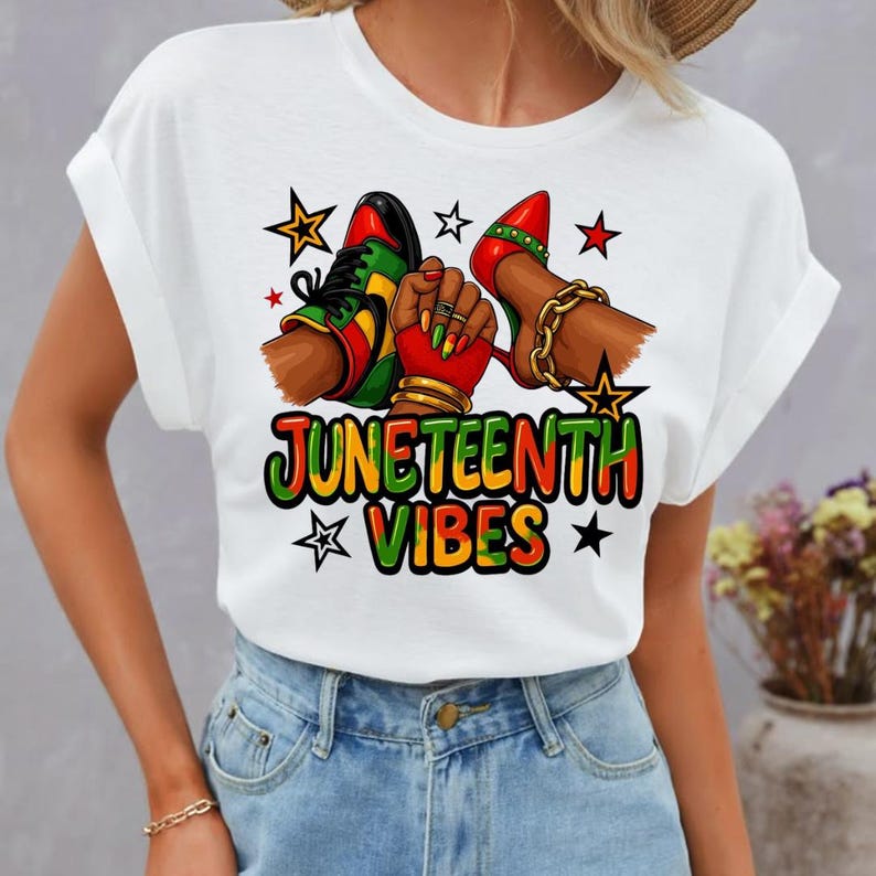 Może przedstawiać: Biała koszulka z kolorową grafiką. Projekt zawiera napis "JUNETEENTH VIBES", parę but&oacute;w, pięść i gwiazdy. Kolory to czerwony, zielony, ż&oacute;łty i czarny.
