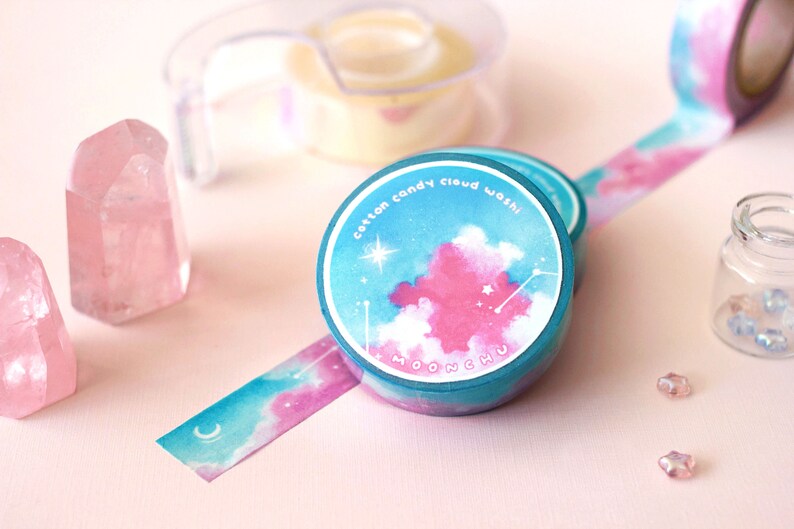 Op de afbeelding: Een rol washi tape in teal en roze met een ontwerp van een witte wolk en sterren. Het label luidt "cotton candy cloud washi MOONCHU".