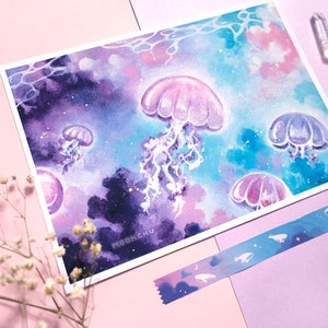 Puede incluir: Pintura acuarela de medusas nadando en un oc&eacute;ano parecido a una galaxia. Las medusas son rosas, moradas y azules, y el fondo es una mezcla de azul oscuro, morado y rosa.