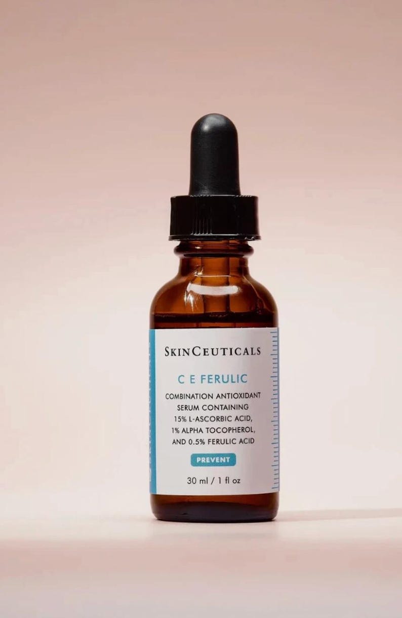 May include: A brown glass bottle of SkinCeuticals C E Ferulic serum with a black dropper. The label includes the text "COMBINATION ANTIOXIDANT SERUM CONTAINING 15% L-ASCORBIC ACID, 1% ALPHA TOCOPHEROL, AND 0.5% FERULIC ACID". The bottle contains 1 fl oz of serum.