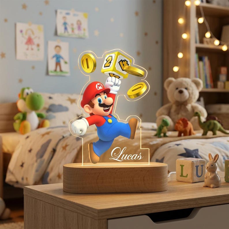 May include: A custom acrylic LED night light featuring a colorful Mario character jumping toward a yellow question block and gold coins. The clear acrylic panel is engraved with the name Lucas and is mounted on a smooth, oval wooden base.