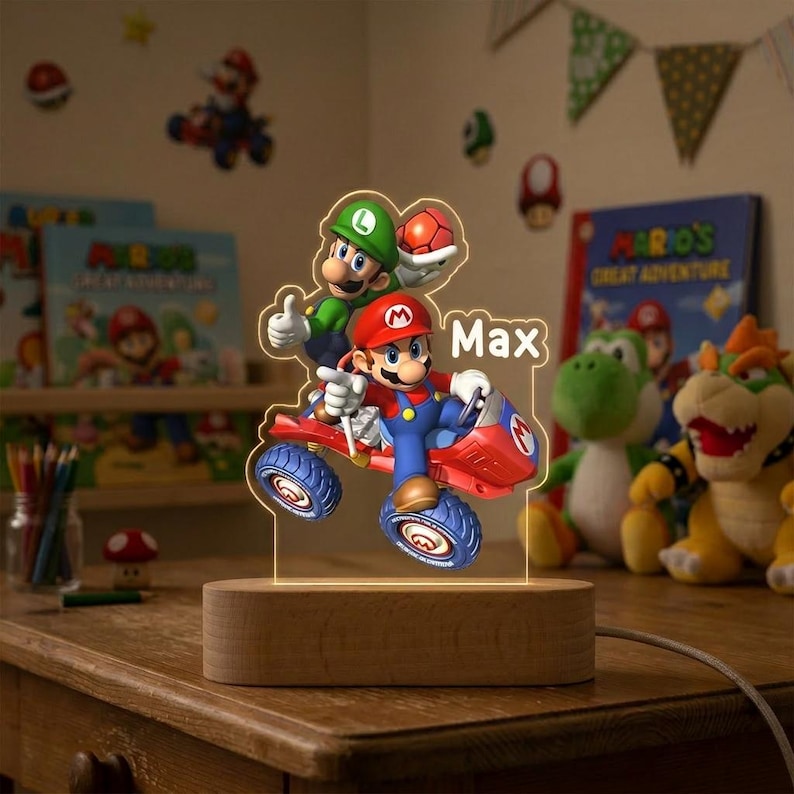 May include: A custom LED night light featuring a 3D-style acrylic cutout of Mario and Luigi driving a red go-kart. The name Max is printed in white text next to the characters. The light is mounted on a smooth, oval-shaped wooden base.