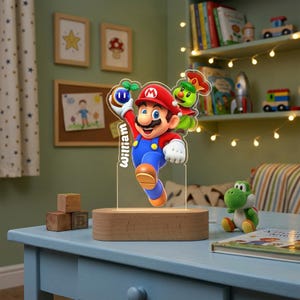 May include: A custom acrylic LED night light featuring a colorful graphic of Mario holding a blue item with a green sprout, accompanied by a green character. The name William is printed vertically on the acrylic, set on a light wood base.