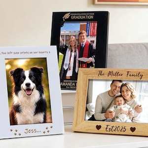 Könnte beinhalten: Drei Bilderrahmen auf einer weißen Oberfläche. Ein weißer Rahmen zeigt ein Hundefoto mit dem Text "...You left paw prints on our hearts x" und "Jess...". Ein schwarzer Rahmen enthält ein Abschlussfoto. Ein holzfarbener Rahmen zeigt ein Familienfoto mit dem Text "The Miller Family" und "Est2025".