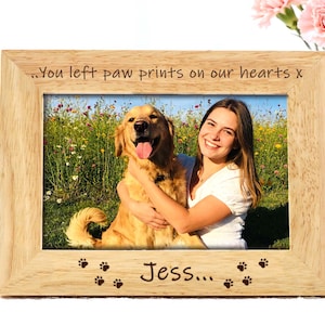 Peut inclure: Cadre photo rectangulaire en bois clair avec une photo d'une femme et d'un chien golden retriever. Le cadre porte l'inscription "...You left paw prints on our hearts x" et "Jess...", ainsi que des empreintes de pattes.