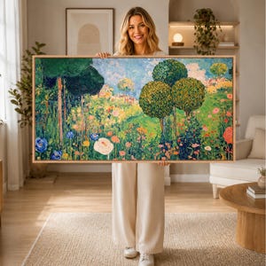 Può includere: Un grande dipinto paesaggistico rettangolare in una cornice di legno chiaro che raffigura una vivace scena di giardino con alberi verdeggianti, arbusti arrotondati e una varietà di fiori colorati, tra cui boccioli blu, bianchi e arancioni.