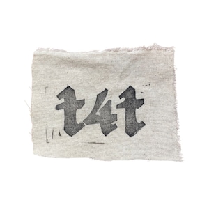 May include: A beige fabric patch with the word "t4t" printed in black.