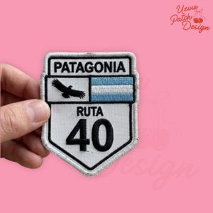 May include: A white patch with a black border featuring the word "PATAGONIA" above a design of a bird and the Argentinian flag. Below is "RUTA 40" and the number "40".