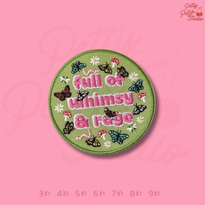May include: Embroidered patch with a green circular design featuring butterflies, mushrooms, and the text "full of whimsy & rage" in pink. The patch is surrounded by a pink background and size options from 3 to 9 inches.