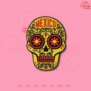 May include: Yellow embroidered skull patch with the word "MEXICO" in orange. The skull features orange flower-shaped eyes and a red row of teeth. The patch is decorated with black swirls and is available in sizes from 3 to 9 inches.