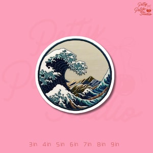 May include: Round embroidered patch featuring a stylized depiction of a large ocean wave in shades of blue and white, with mountains in the background. The patch is surrounded by a white border and set against a pink background. The patch is available in sizes from 3 inches to 9 inches.