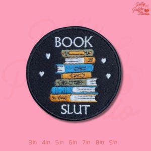 May include: Embroidered patch with a black background featuring a stack of books in various colors. The words "BOOK" and "SLUT" are embroidered in white. White heart shapes surround the design. The patch is available in sizes from 3 to 9 inches.