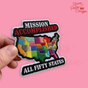 May include: A white ceramic mug with a black handle and the text "But First, Coffee" in a black, bold font. The mug is on a white surface.