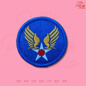 May include: Embroidered patch featuring a blue circle with gold wings and a white star with a red center. The patch is approximately 3 inches in diameter. The text "Petty Patch Studio" is in the upper right corner.