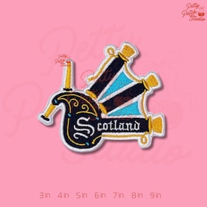 May include: Embroidered patch featuring a stylized bagpipe design with the word "Scotland" in white. The patch has a black, gold, and blue color scheme, with the text outlined in white. The patch is approximately 3 inches to 9 inches in size.