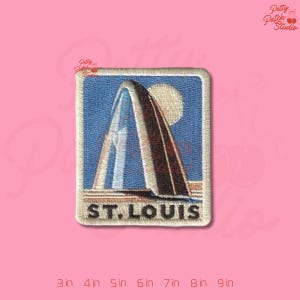 May include: Embroidered patch featuring the Gateway Arch in St. Louis, Missouri. The patch has a blue background with the arch in shades of brown and white, a yellow sun, and the text "ST. LOUIS". The patch is rectangular with rounded corners.