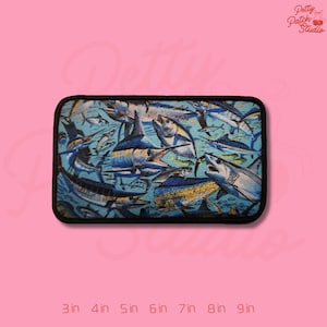 May include: Rectangular patch featuring a vibrant aquatic scene with various fish, including marlin and sharks, in shades of blue and white. The patch has a black border and is labeled with size options from 3 to 9 inches.