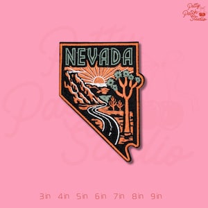 May include: Embroidered patch featuring a Nevada landscape design. The patch has a black border with the word "NEVADA" in green. The design includes a road, mountains, a sun, and trees. The patch is approximately 3 inches to 9 inches in size.