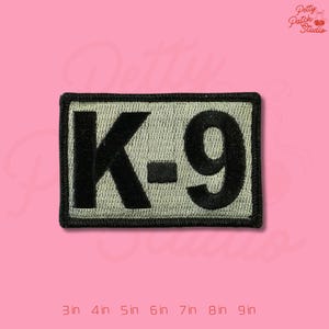 May include: A rectangular patch with the text "K-9" in black, outlined in black, on a light green background. The patch is bordered with a black trim. The image also includes size options from 3 inches to 9 inches.