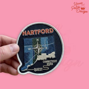 May include: Embroidered patch featuring the city name "Hartford" in red and white lettering. The patch depicts a map of Connecticut with a compass rose, the text "Connecticut River" and "Quest". The patch is on a navy blue background.