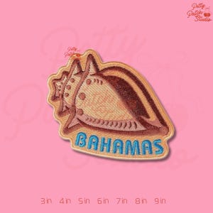 May include: Embroidered patch featuring a seashell design with brown and tan colors. The word "BAHAMAS" is embroidered in blue. The patch is approximately 3 inches wide.