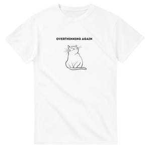 May include: White t-shirt featuring the text "OVERTHINKING AGAIN" and a black line drawing of a cat. The cat is depicted sitting with closed eyes and a small smile.