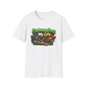 Könnte beinhalten: Ein weißes T-Shirt mit einem Grafikdruck und dem Text "Debugging My Life". Das Design zeigt einen Computerbildschirm, eine Lupe über einem roten Käfer, eine grüne Kaffeetasse, ein gebrochenes Herz, Werkzeuge und einen Ladebalken bei 45 Prozent.