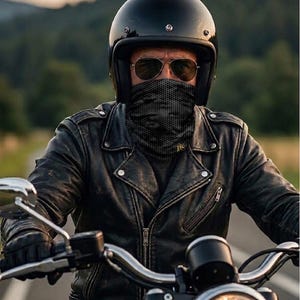 Könnte beinhalten: Eine Person mit einem schwarzen Motorradhelm, Sonnenbrille und einer schwarzen gemusterten Gesichtsbedeckung, die Motorrad fährt. Die Person trägt eine schwarze Lederjacke. Das Motorrad hat einen hellen Scheinwerfer. Der Text "Öko-Tex" ist sichtbar.