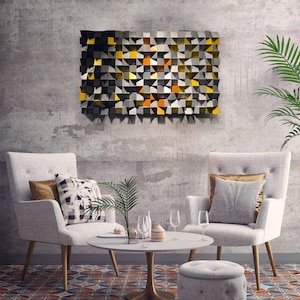 Puede incluir: Arte mural abstracto con un diseño geométrico en negro, gris, amarillo y naranja. La obra de arte está montada en una pared de hormigón sobre dos sillones blancos, una pequeña mesa redonda y una alfombra estampada.