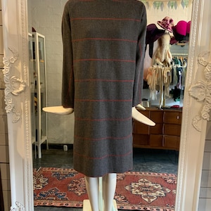 May include: A gray and red striped dress with long sleeves and a round neckline.