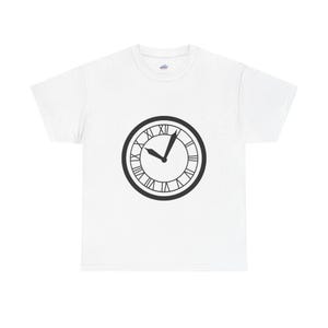 Puede incluir: Camiseta blanca con un diseño de reloj negro. La esfera del reloj muestra números romanos y las manecillas señalan aproximadamente las 10:05. El diseño está centrado en la camiseta, creando un efecto visual simple pero llamativo.