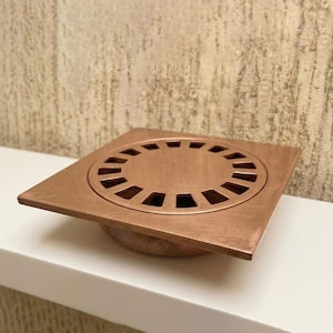 Könnte beinhalten: Ein Set aus drei Keramikbechern mit gesprenkelter, matter Oberfläche. Die Becher sind in Creme-, Hellgrau- und Dunkelgrautönen gehalten. Jeder Becher hat ein schlichtes, minimalistisches Design, perfekt für Kaffee oder Tee.
