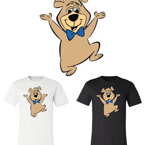 May include: A cartoon bear with a blue bow tie is featured on a white and black t-shirt. The bear is light brown with a black outline and is smiling with its arms open. The image also shows the bear graphic on its own.