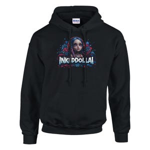 Puede incluir: Sudadera con capucha negra con un diseño gráfico de una chica con pelo azul, rodeada de rosas y el texto "INKEDDOLLAI". La sudadera tiene un bolsillo delantero y una capucha con cordón.