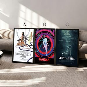 Puede incluir: Tres pósteres enmarcados de Ghost in the Shell etiquetados como A, B y C. El póster A presenta un fondo blanco con un personaje conectado a cables. El póster B muestra un diseño circular vibrante en rosa y azul. El póster C muestra una escena oscura.