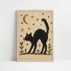 Pode incluir: Um bordado em ponto cruz sobre tecido bege claro apresentando um gato preto com as costas arqueadas. O design inclui uma lua crescente dourada, pequenas estrelas douradas e azul-escuras, e elementos florais verdes e castanhos na base.