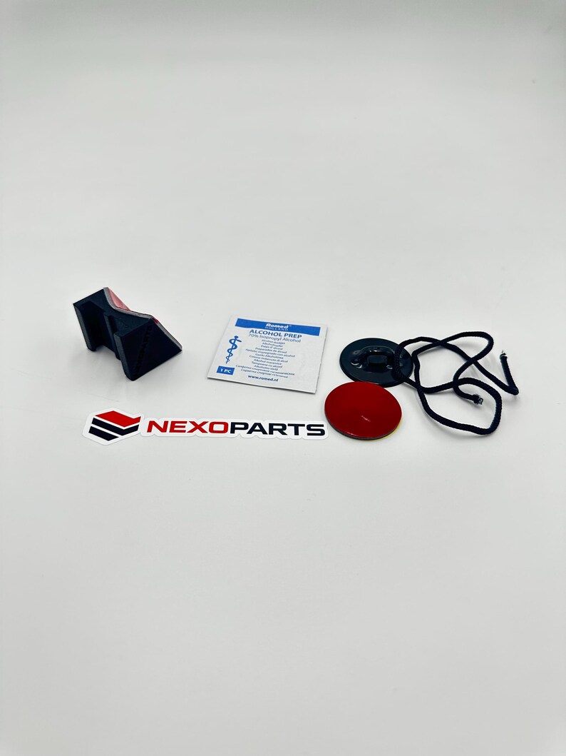 May include: An assortment of automotive parts, including a black and red bracket, a red circular sticker, a black disc with a cord, and a small packet labeled "Alcohol Prep". The Nexoparts logo is also visible.