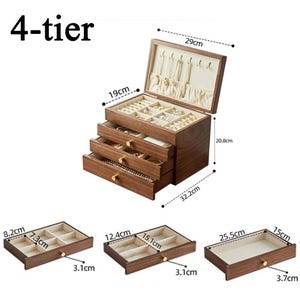 May include: A 4-tier wooden jewelry box with multiple drawers and compartments. The box is 32.2cm long, 29cm wide, and 20.8cm tall. The drawers are lined with a beige fabric. The top section has necklace hooks. The text "4-tier" is at the top.