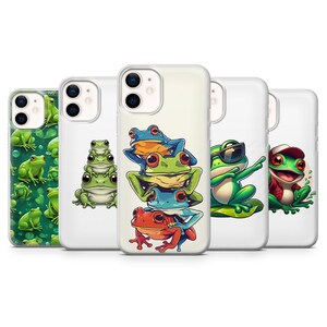 May include: A collection of phone cases featuring cartoon frogs in various poses. The cases display frogs in shades of green, blue, and red, with some wearing sunglasses or hats. The cases have a white background.