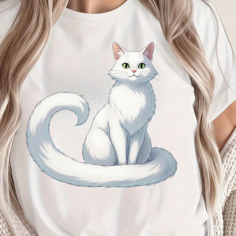 May include: White t-shirt featuring a detailed illustration of a fluffy white cat with green eyes. The cat is sitting with its tail curled around its body. The design is centered on the shirt, creating a simple yet eye-catching design.
