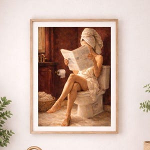 Könnte beinhalten: Ein gerahmter Wandkunstdruck mit einem Gemälde einer Person mit einem Handtuch um den Kopf, die auf einer Toilette sitzt und eine Zeitung in einem Badezimmer mit dunkelroten Wänden liest, präsentiert in einem hellen Badezimmer mit weißer Wanne.
