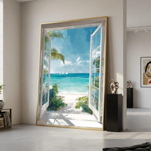 Puede incluir: Una obra de arte enmarcada que representa una ventana abierta con vistas a una escena de playa tropical. La obra presenta un cielo azul brillante, agua turquesa, arena blanca y palmeras. El marco de la ventana es blanco con un borde dorado.