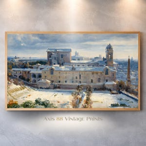 May include: A framed vintage painting depicts a snow-covered cityscape with buildings, a tower, and an obelisk under a cloudy sky. The artwork is in a wooden frame, with the text "Axis 88 Vintage Prints" at the bottom.
