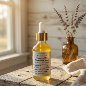 May include: A clear glass bottle of Turmeric Skin Brightening Serum with a gold dropper top sits on a rustic wooden table. The label reads "Enchanted Sea Nymph" and "Face & Body Oil." A small brown vase with lavender and a linen cloth are in the background.