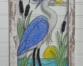 Kunstwerk van een blauwe reiger gemaakt van gebroken glas