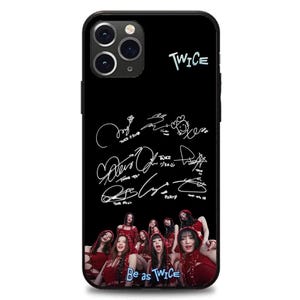 以下が含まれることがあります： 黒いスマートフォンケース。ライトブルーの「TWICE」の文字とサインが特徴。赤い衣装の女性グループの写真と「Be as TWICE」の文字がプリントされています。スマートフォン用ケースです。
