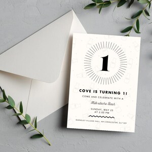 May include: A white invitation card with black text announcing "COVE IS TURNING 1!" and a "Milk-stache Bash". The design includes a number "1" within a circular pattern, a white envelope, and sprigs of green foliage.