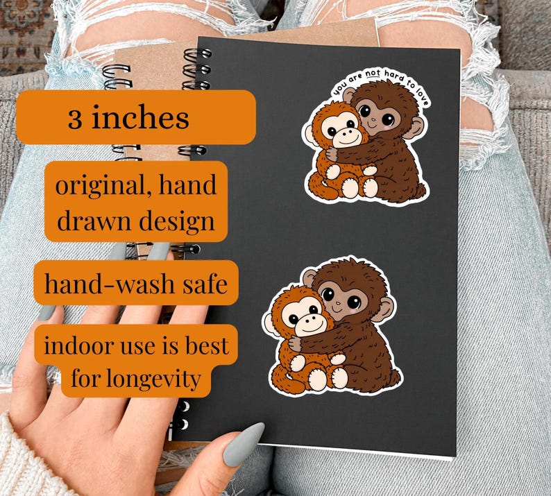 May include: Two stickers featuring cartoon monkeys hugging. The stickers are 3 inches in size and hand-drawn. The text on the stickers reads "you are not hard to love". The stickers are hand-wash safe and best for indoor use.