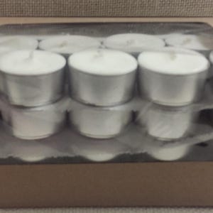 Puede incluir: Una caja de velas de t&eacute; blancas en un recipiente de pl&aacute;stico transparente. Las velas de t&eacute; est&aacute;n dispuestas en filas y est&aacute;n listas para ser usadas.
